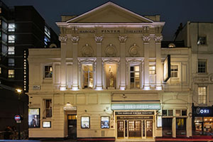 The outside of The Harold Pinter Theatre, illuminated at night